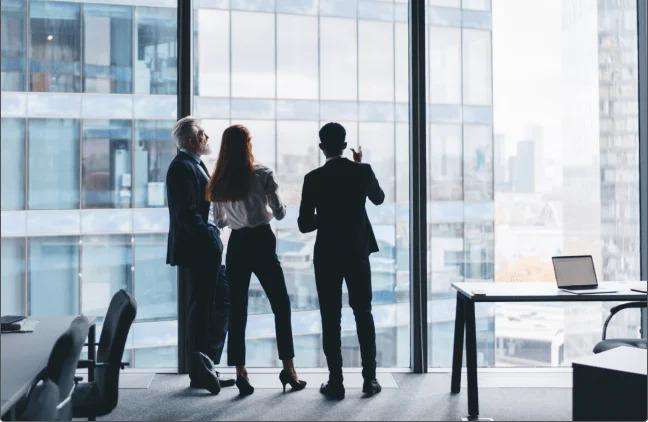 Three professional enginner discuss look outside of building and discuss any plan with each other