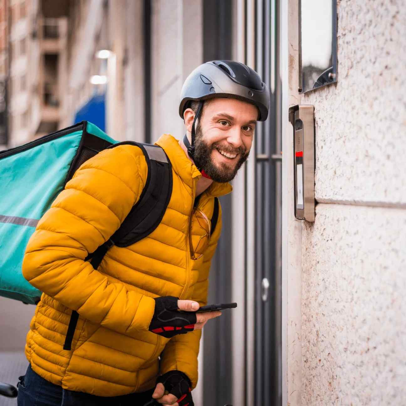 A courier boy who wears yellow jacket and helmet is wait on the door